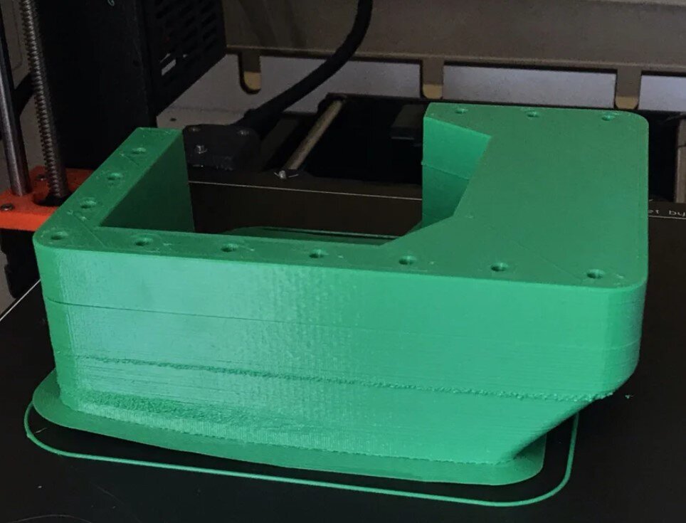Green ABS 3D printed part with visible warping and layer separation
